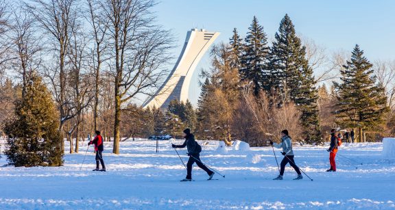 People cross-country skiing in front of the Olympic Stadium.