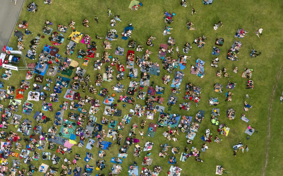 Aerial view of several people sitting on a stretch of grass