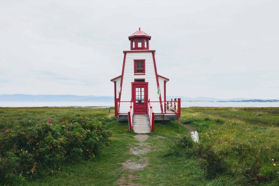 Red and white lighthouse by the water
