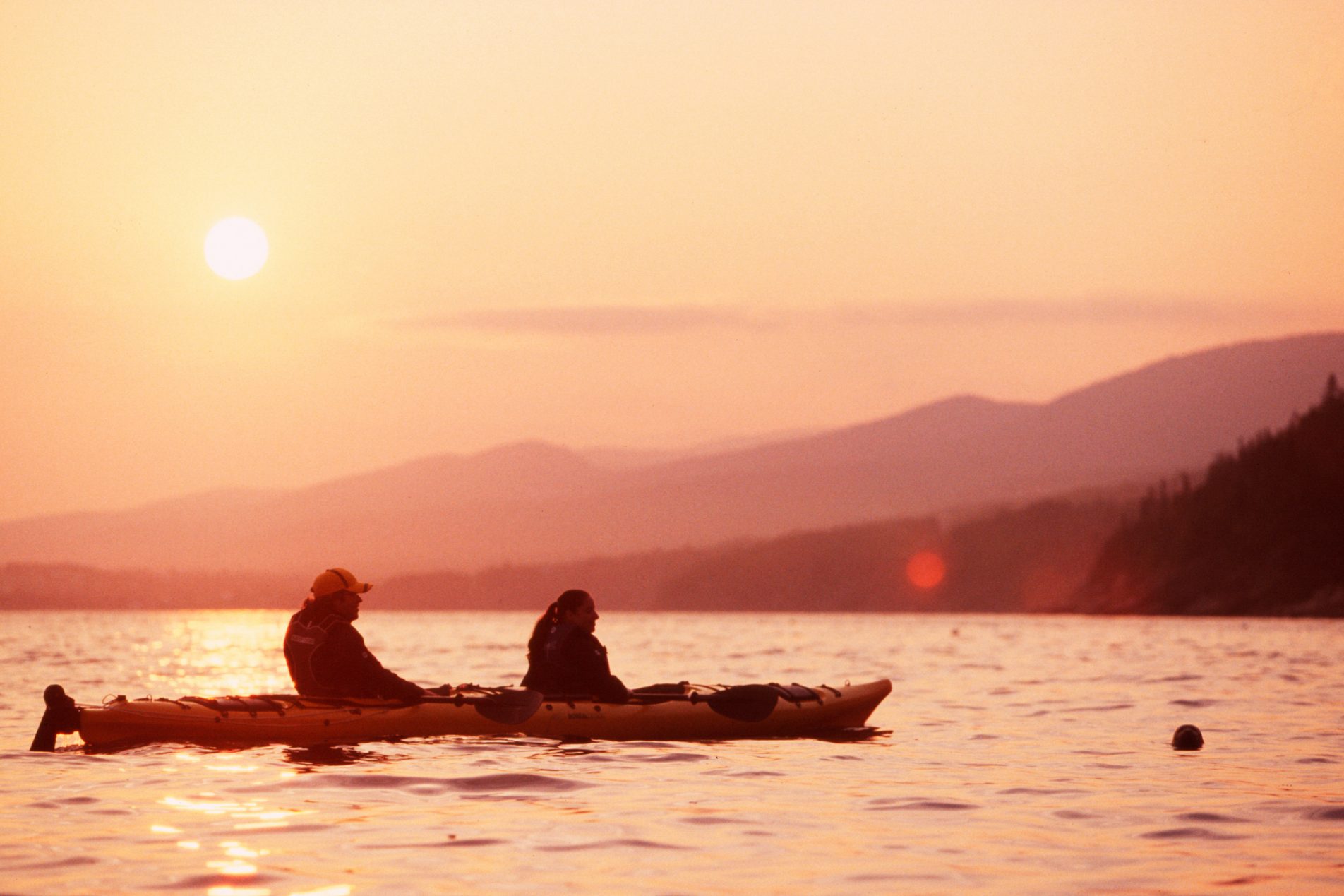 Deux personnes en kayak au coucher de soleil