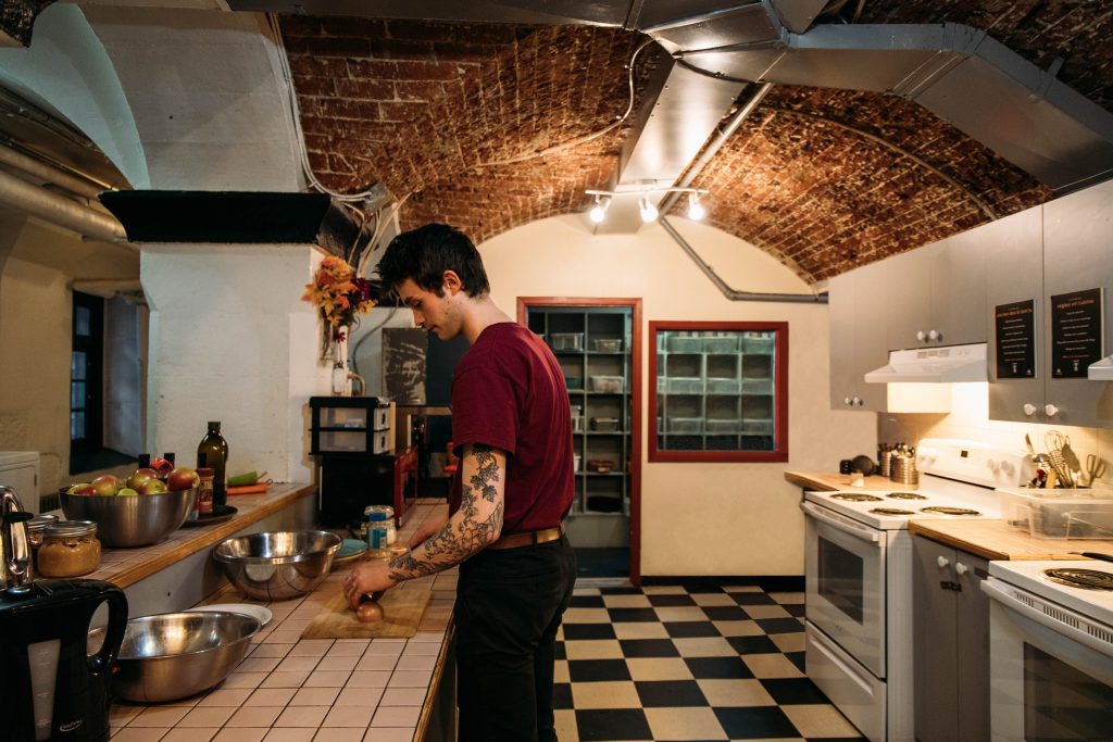 Traveler makes himself a meal in the common kitchen