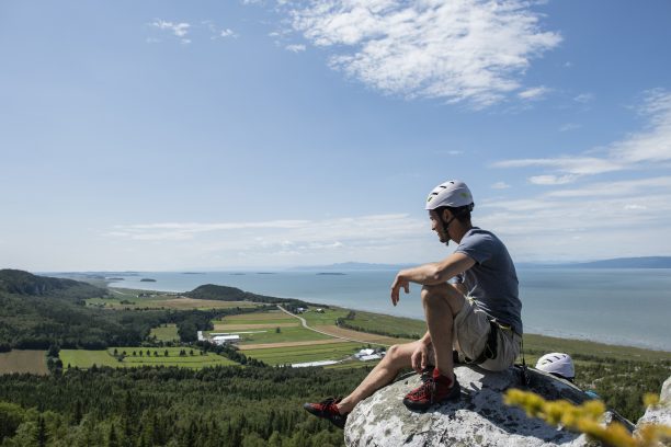 e avec casque au sommet d'une paroi rocheuse