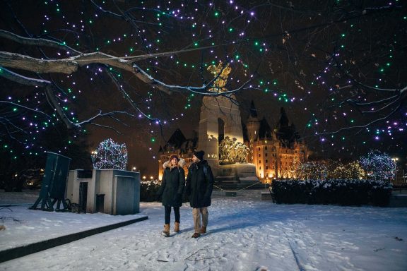 Deux personnes qui marchent dans la neige, lumière dans les arbres