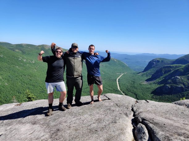 three men on top of a mountain