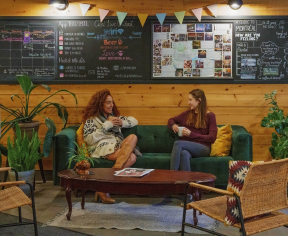 Two friends having tea at the Saintlo Montreal Hostel