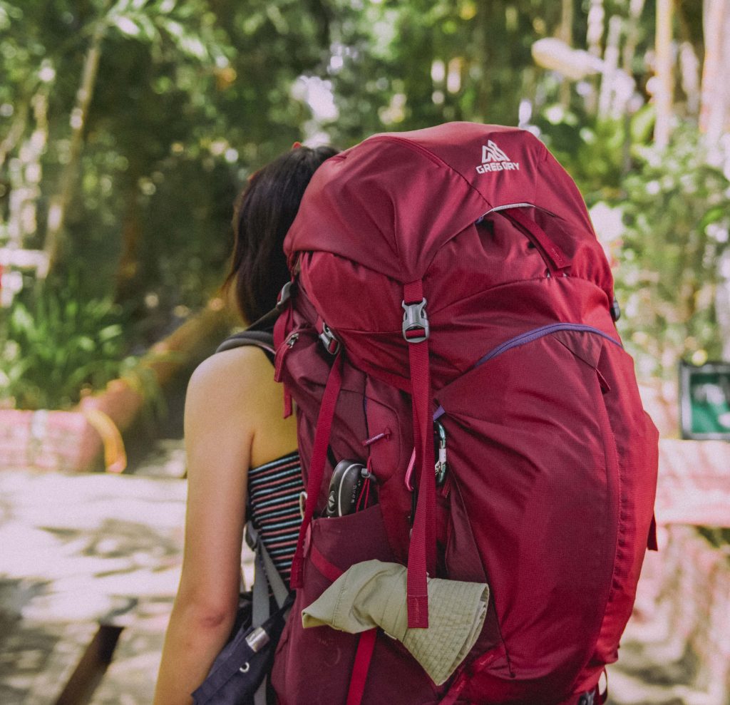 Voyageuse avec un gros sac à dos rouge