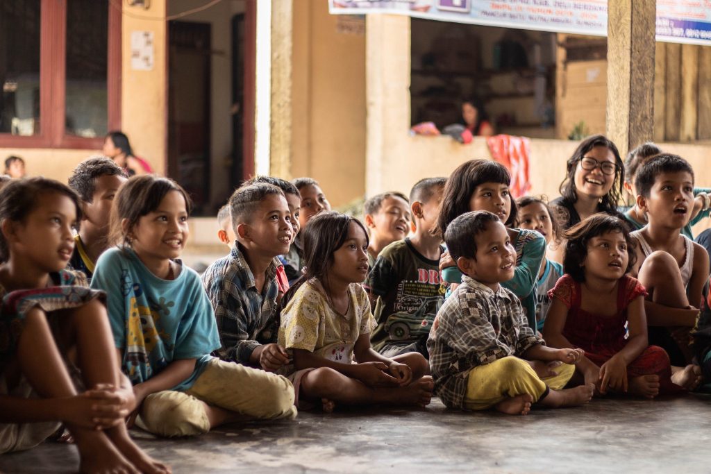 groupe d'enfants souriants assis par terre