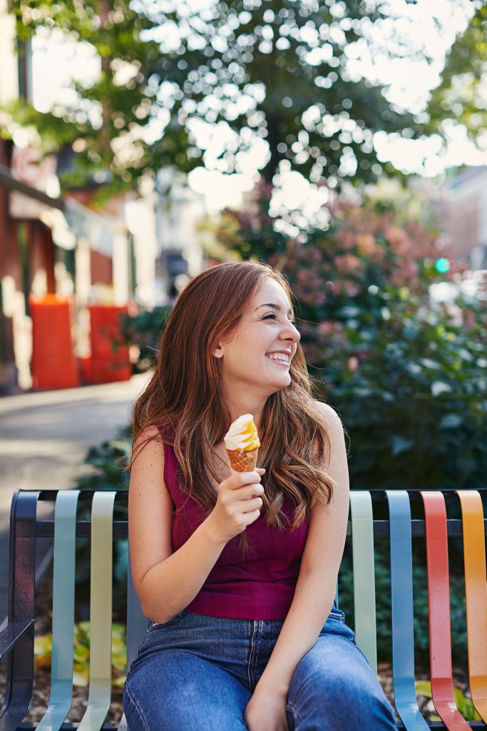 Femme qui mange une crème glacée sur un banc