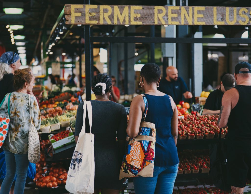 People in front of vegetable stalls at Jean Talon market