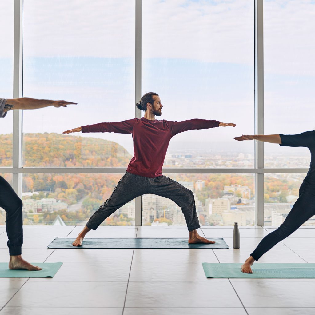 Men doing yoga with a view of Montreal