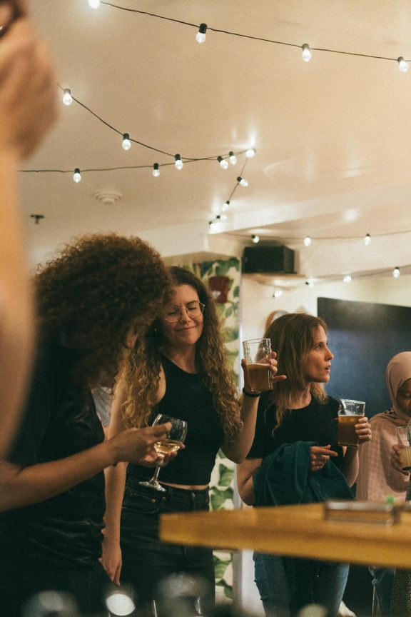 Des personnes dans une soirée, cocktail à la main