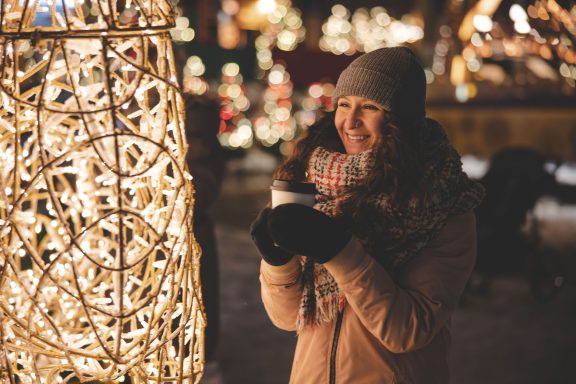 Girl in front of Christmas lights outside