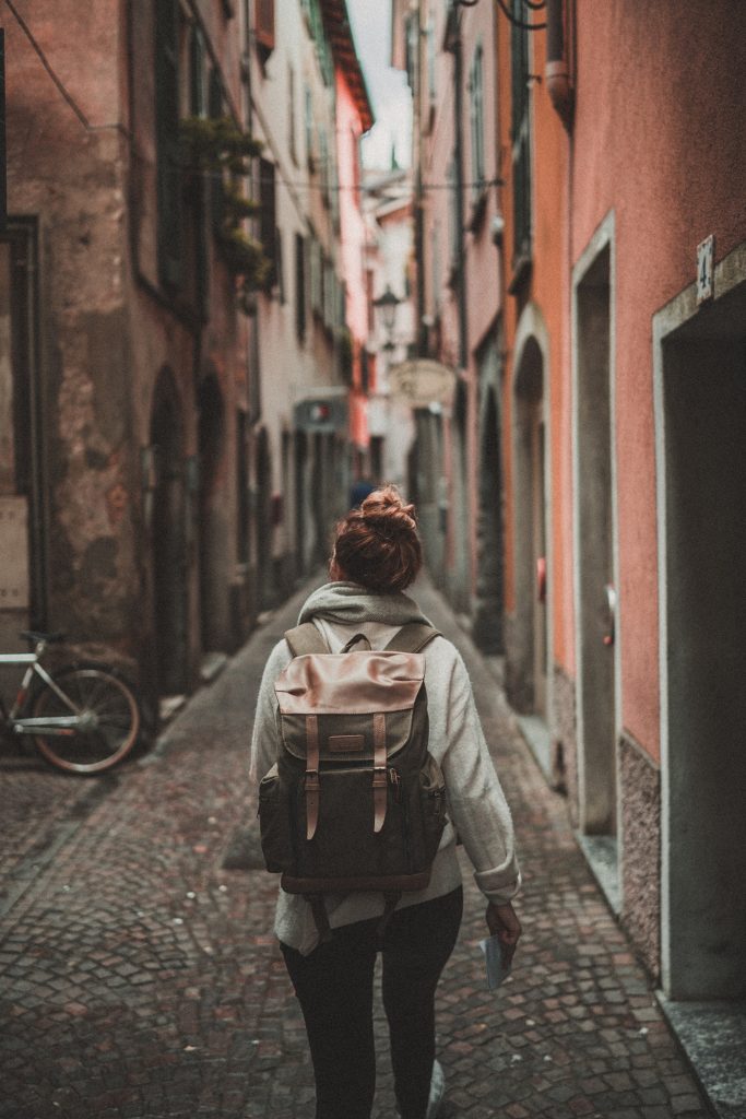 Une personne de dos qui marche dans une ruelle