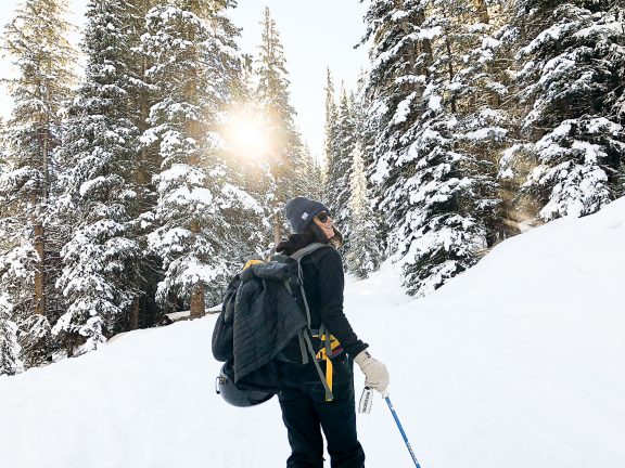 Femme marchant dans la neige dans la forêt