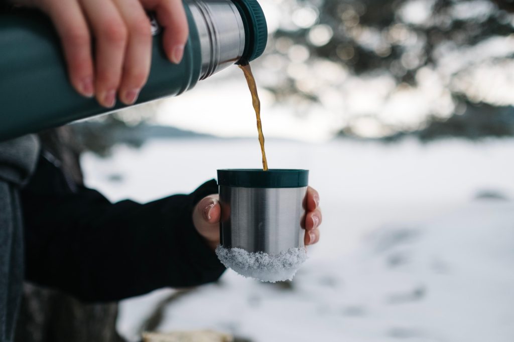 Person pouring hot chocolate from a thermos