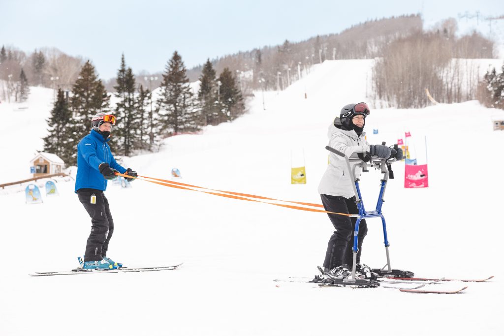 Man helping someone skiing with disabilities or impairments