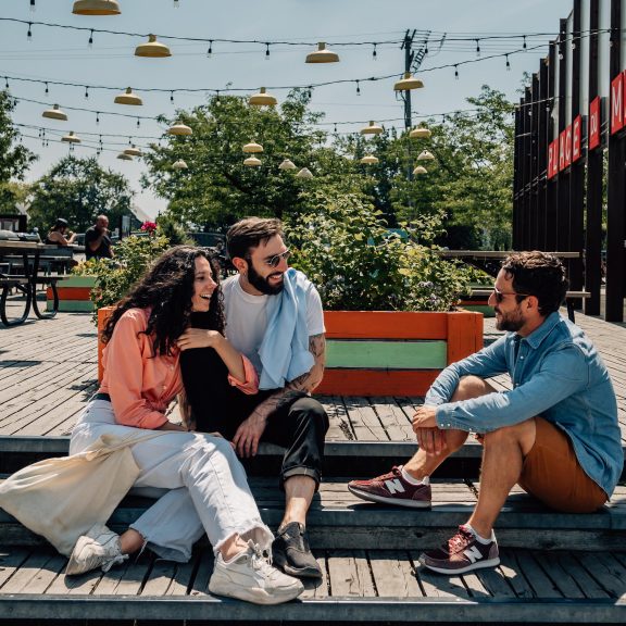 Three people chatting on a colorful terrace
