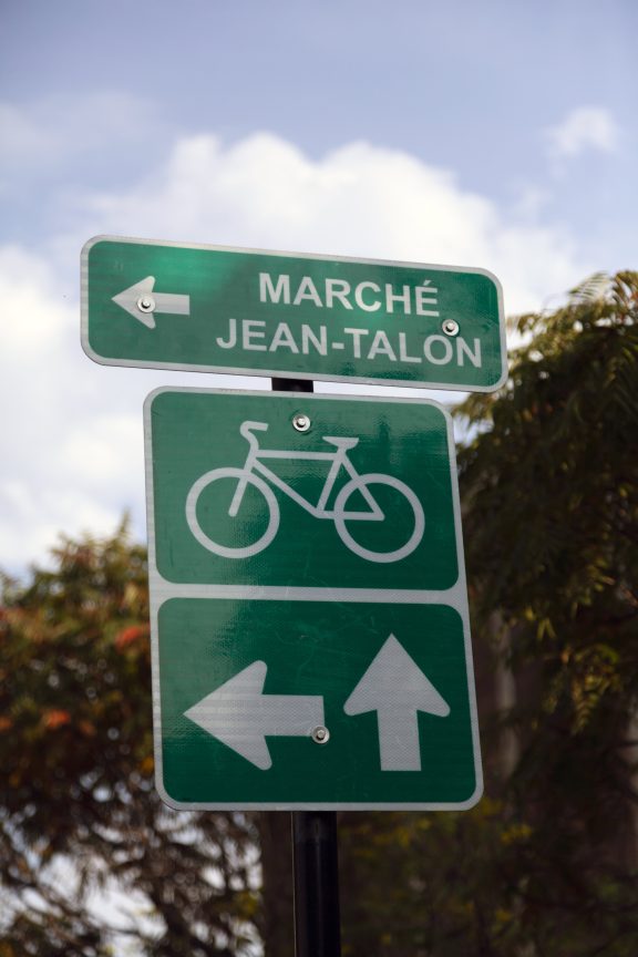Panneau routier qui indique la voie cyclable et la direction vers le marché Jean-Talon