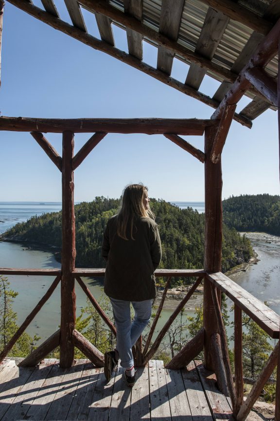 Femme de dos qui observe la Baie des Rochers dans Charlevoix