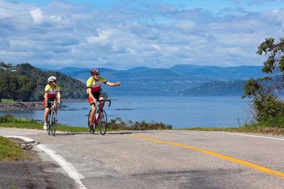 Deux personnes en vélo avec une vue sur le fleuve