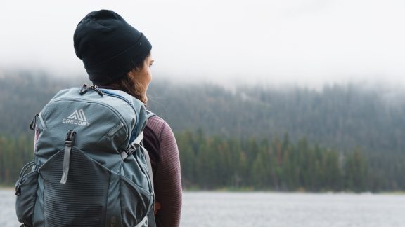 A person from behind in front of a forest