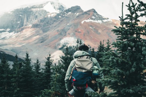 Une personne de dos, devant une montagne