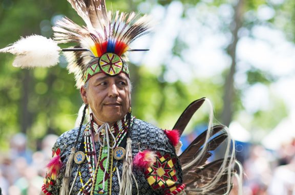 Homme autochtone habillé de vêtements traditionnels lors d'un pow-wow.