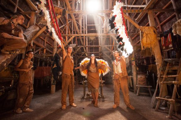 Three Aboriginal people in costume at the traditional Huron site of ONHOÜA CHETEK8E