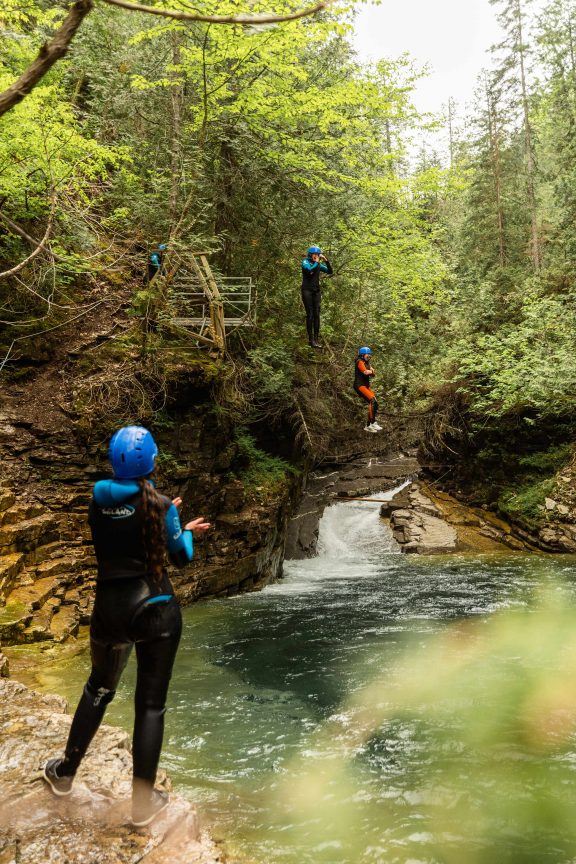 Two people jumping into the water at the Griffon Aventure Inn canyoning activity.