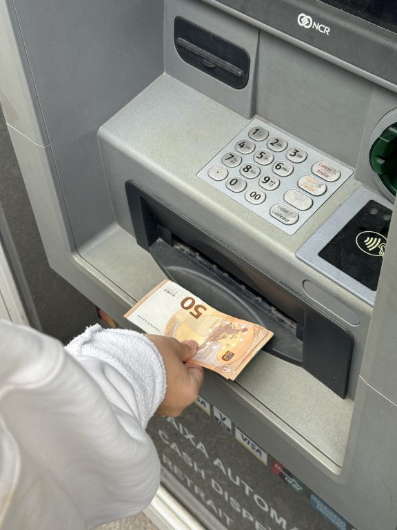 Une personne retire de l'argent à un ATN