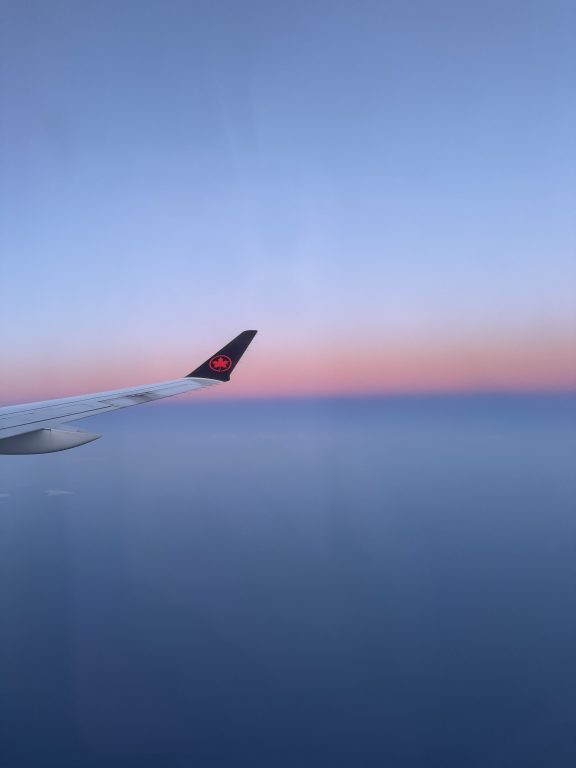 Aile d'avion en vol avec le ciel en fond pour un voyage au canada