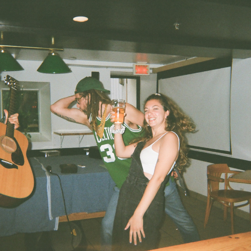 Une personne qui danse avec une bière dans la main